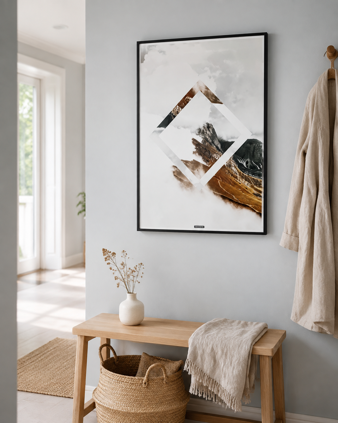 LEVITATE plakat i sort ramme i en lys nordisk entré med egetræsbænk, kurv og dagslys.