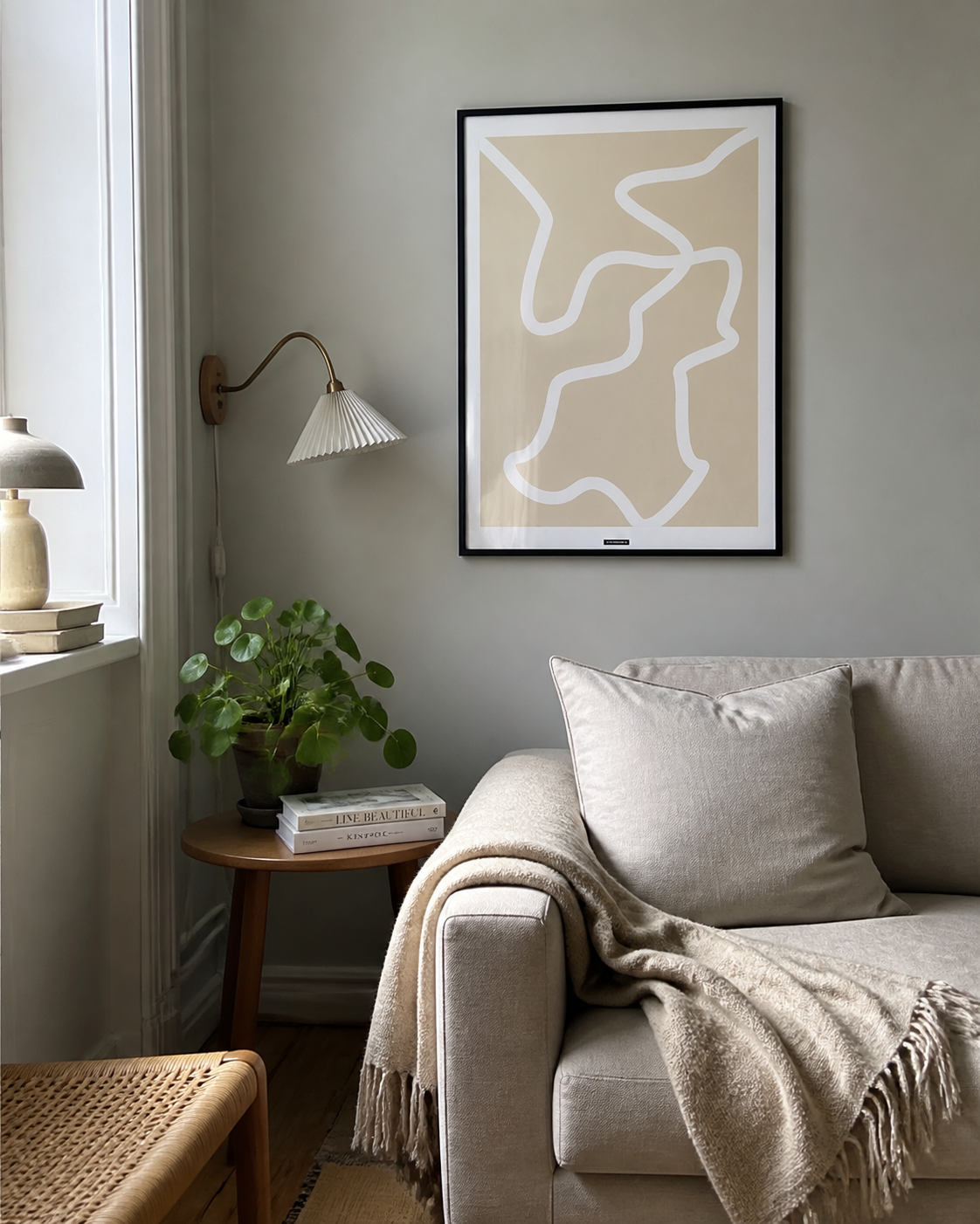 Lines No.1-plakaten med fine organiske linjer i sort ramme hænger på en rolig væg i en naturlig dansk stue med sofa, lampe og dagslys.