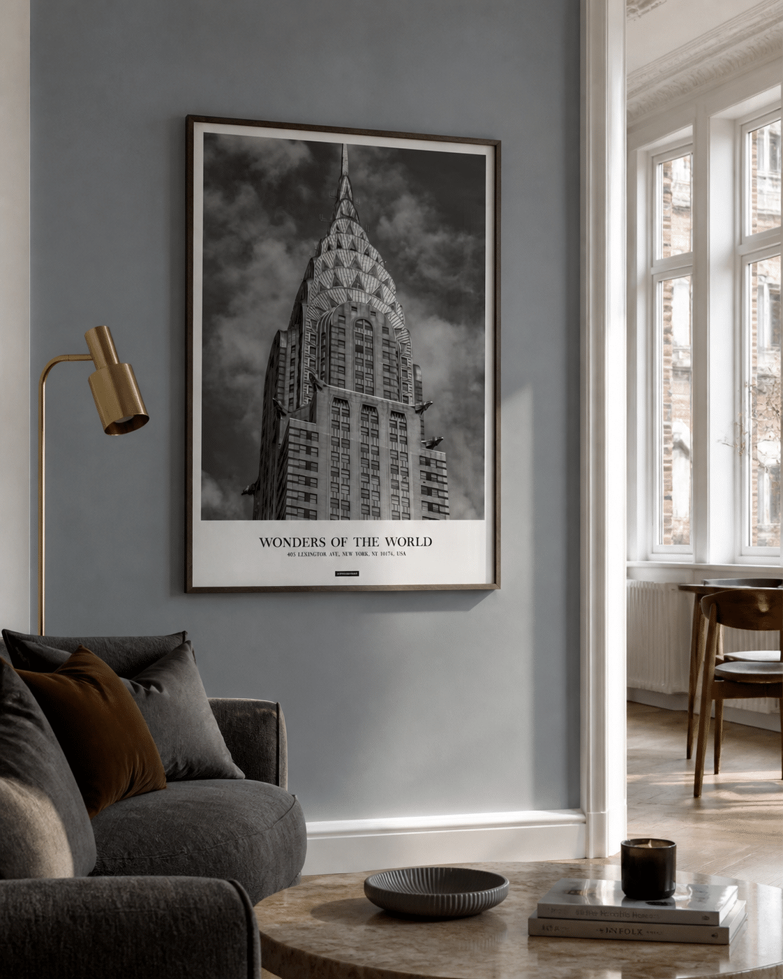 New York plakat i mørk træramme på en blå væg ved siden af et lyst vindue i en moderne stue