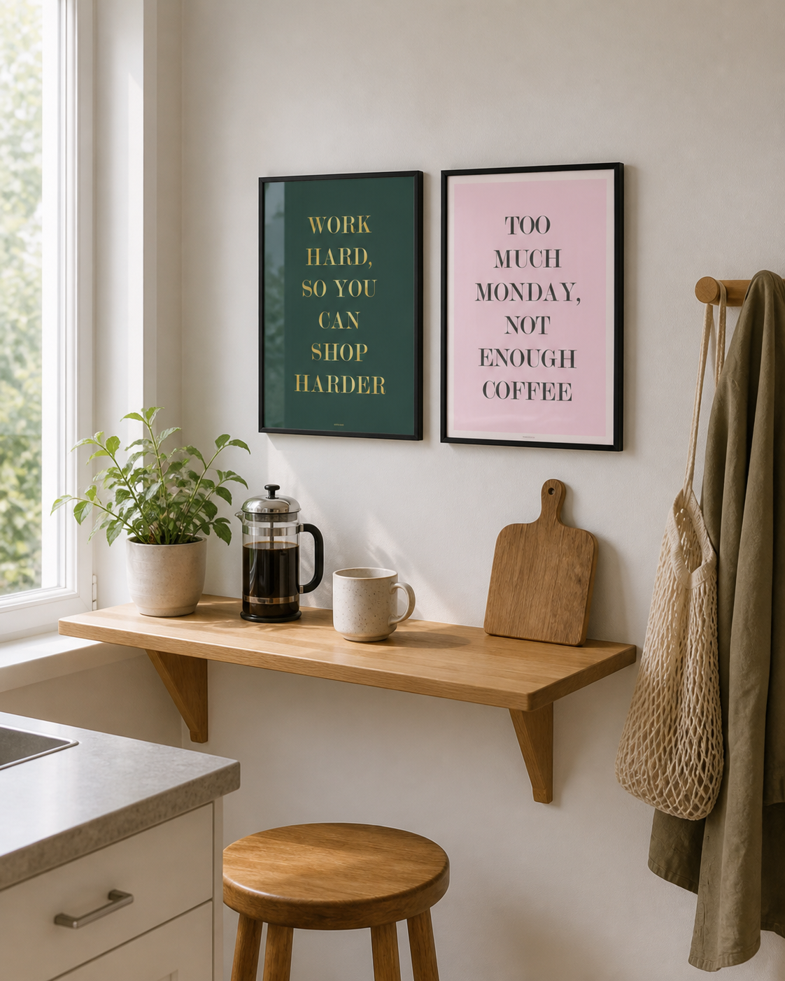 NOT ENOUGH COFFEE og SHOP HARDER plakater i sorte rammer over en lys køkkenhylde med kaffe