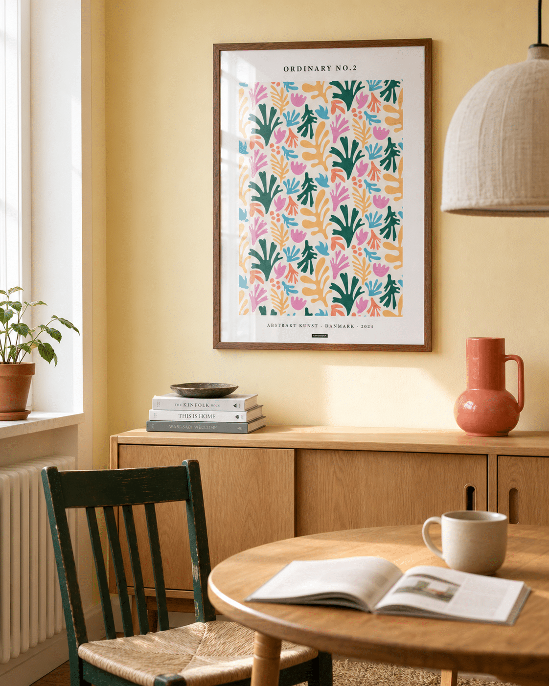 ORDINARY NO.2 plakat i valnøddefarvet ramme i en lys dansk spisestue med lysegul væg, egetræsskænk, grøn stol og naturligt dagslys