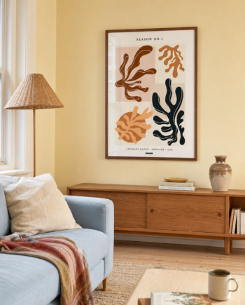 SEASON NO.1 plakat i valnøddefarvet ramme i en lys dansk stue med smørgul væg, lyseblå sofa, valnøddeskænk og flettet gulvlampe