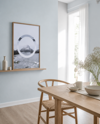 THE SEA plakat i en lys nordisk spisestue med blå væg, egetræsbord og vindueslys