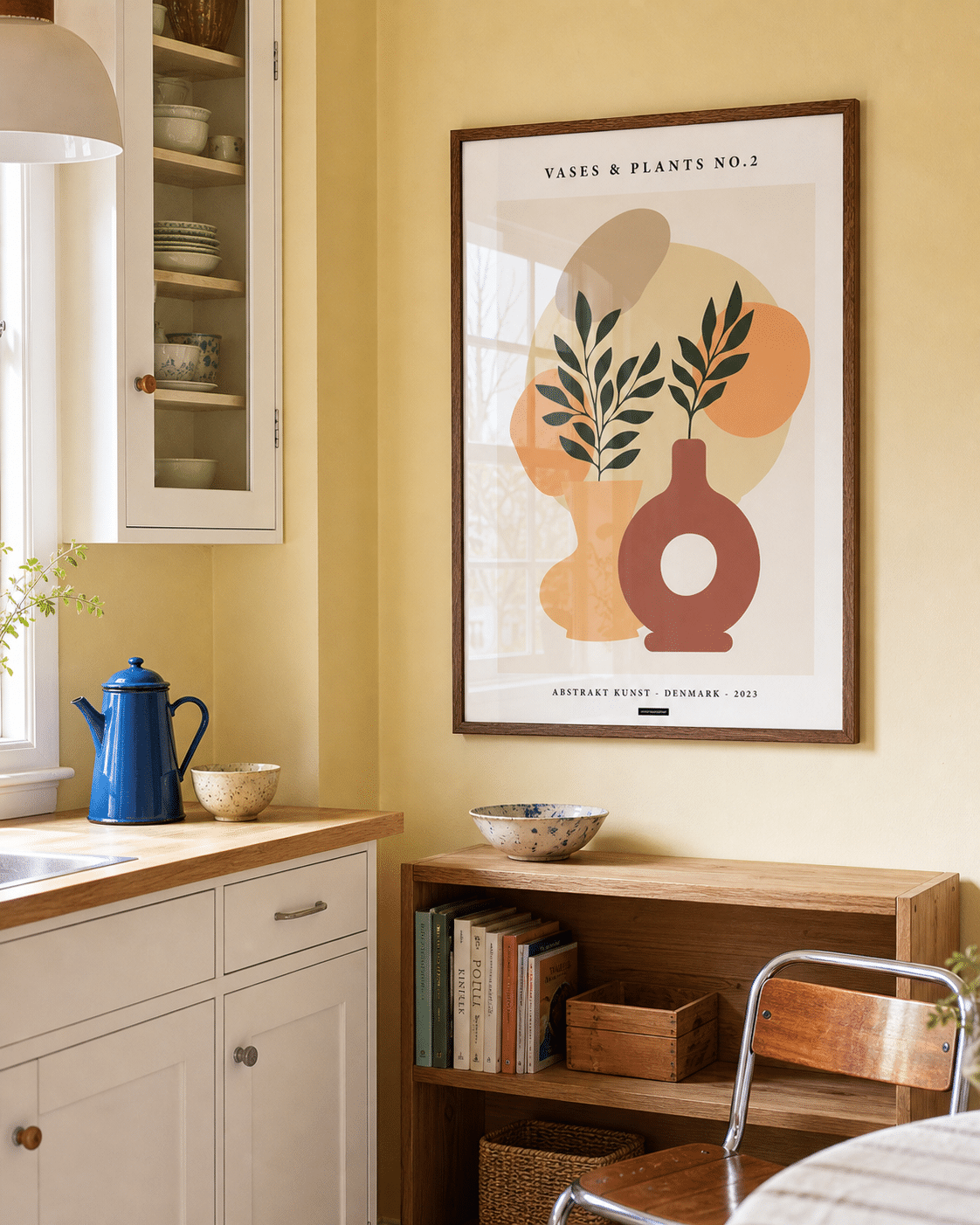 VASES AND PLANTS NO.2 plakat i valnødderamme i et lyst dansk køkken med gul væg, egetræsskab, blå kande og dagslys